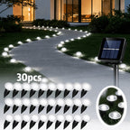Solar pathway lights illuminating a driveway at dusk