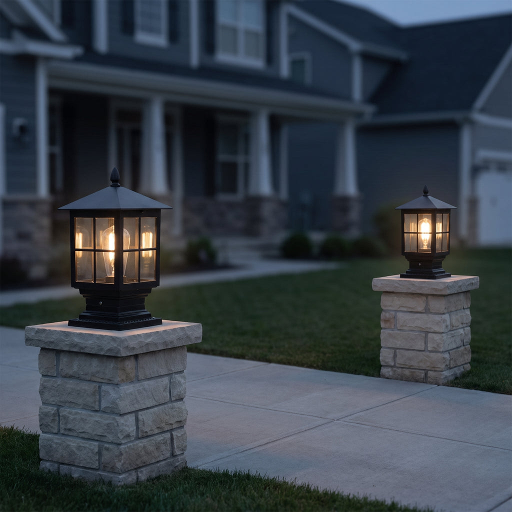 Pair of Ironwood solar pillar lights flanking a driveway at dusk, glowing
